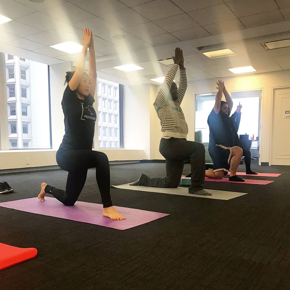 A corporate yoga class in an office in Battery Park, NYC