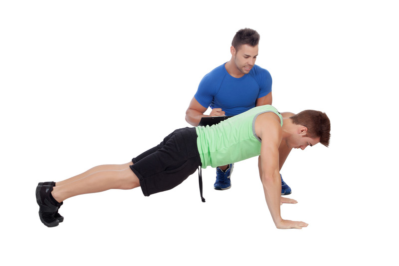 A male trainer coaching a client doing push-ups